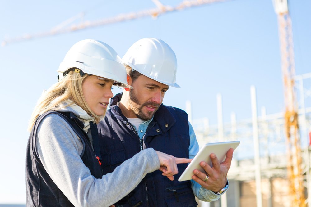 Building staff on a construction site using an iPad for energy audit